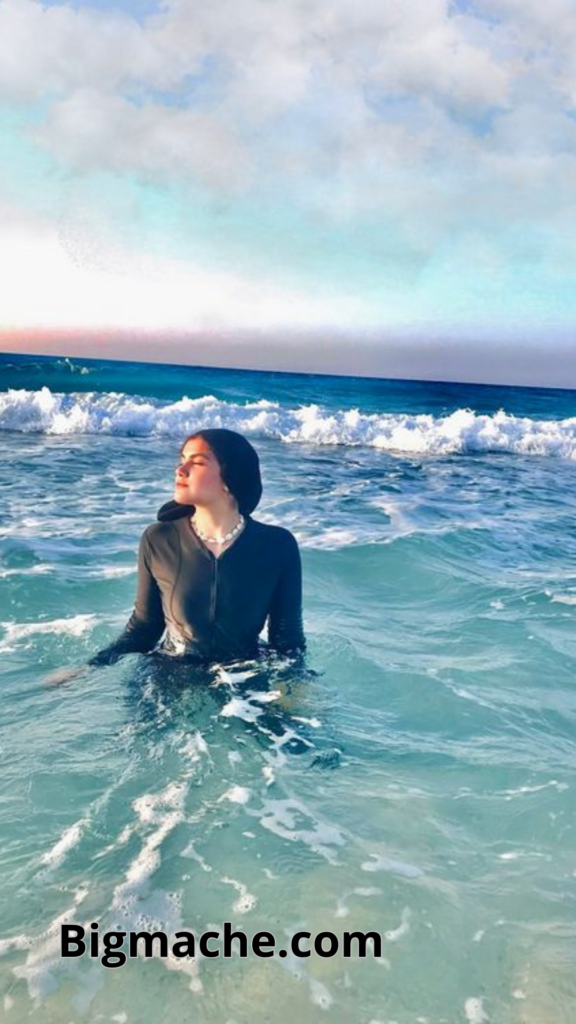 صورة بنت محجبة تجلس على البحر